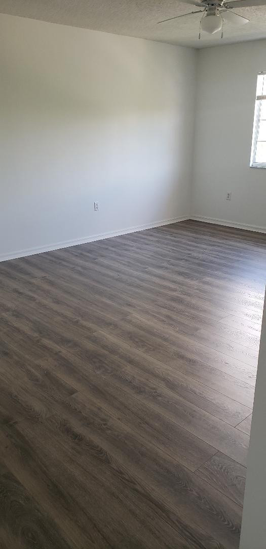 5011 Wiles Road, Unit 301 Coconut Creek, FL 33073 - Photo 16 of 16 an empty room with wooden floor and windows