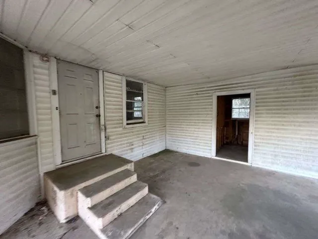 a view of a livingroom with an empty space and deck kitchen