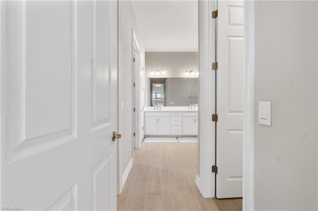 18684 Ensenada Drive Naples, FL 34114 - Photo 17 of 34 a view of a bathroom from a hallway
