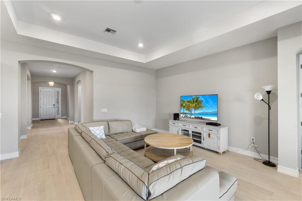 18684 Ensenada Drive Naples, FL 34114 - Photo 4 of 34 a living room with furniture a flat screen tv and a table