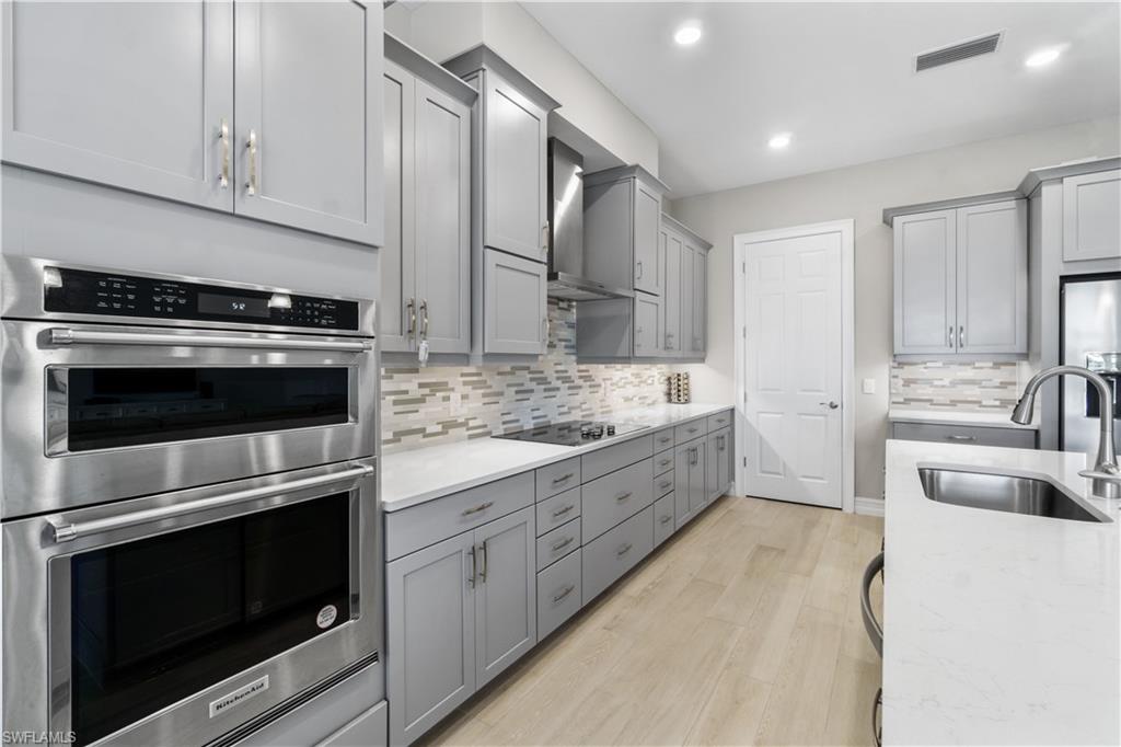 18684 Ensenada Drive Naples, FL 34114 - Photo 9 of 34 a kitchen with granite countertop cabinets stainless steel appliances and a sink