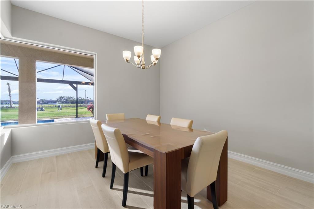 18684 Ensenada Drive Naples, FL 34114 - Photo 10 of 34 a view of a dining room with furniture a chandelier and wooden floor
