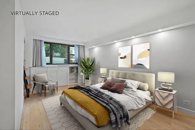a bedroom with a bed and potted plant on table