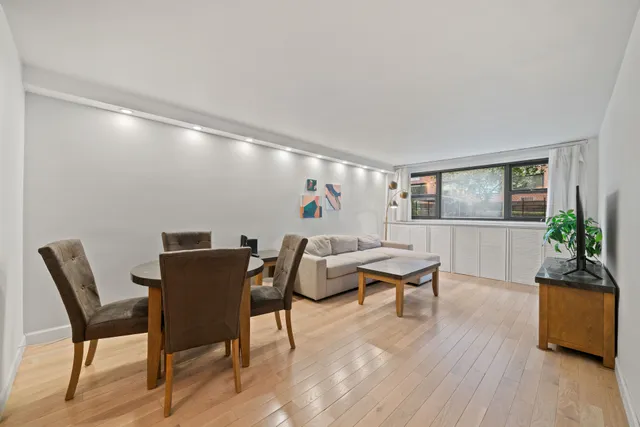 a living room with furniture a wooden floor and a large window