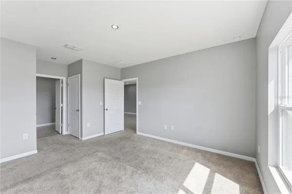 an empty room with windows and closet