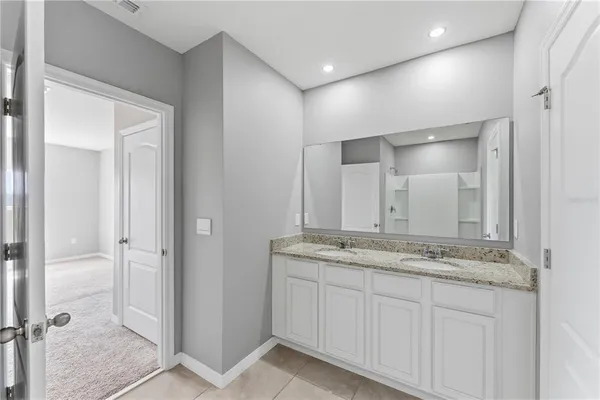 a bathroom with a granite countertop sink and a mirror