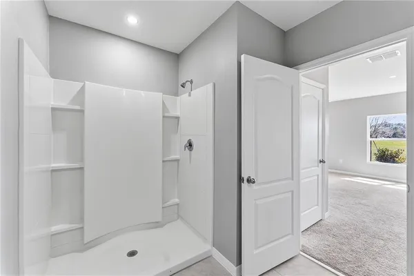 a bathroom with a shower and a glass door