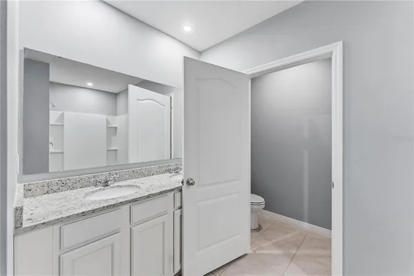 a bathroom with a granite countertop sink and a mirror