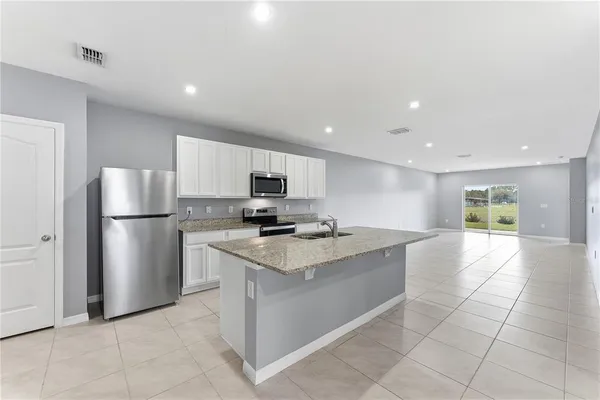 a kitchen with stainless steel appliances a refrigerator sink and microwave