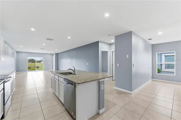 a kitchen with stainless steel appliances granite countertop a sink and a refrigerator