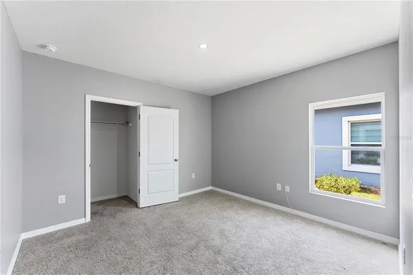 an empty room with windows and mirror