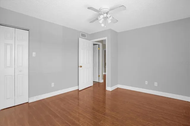 a view of an empty room with wooden floor
