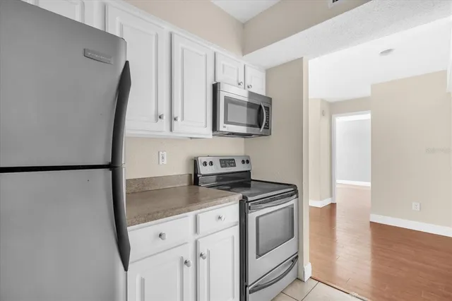 a kitchen with white cabinets and stainless steel appliances
