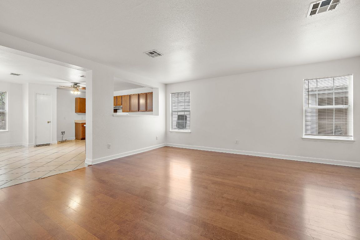 13718 Merseyside Drive Pflugerville, TX 78660 - Photo 1 of 13 an empty room with wooden floor and windows