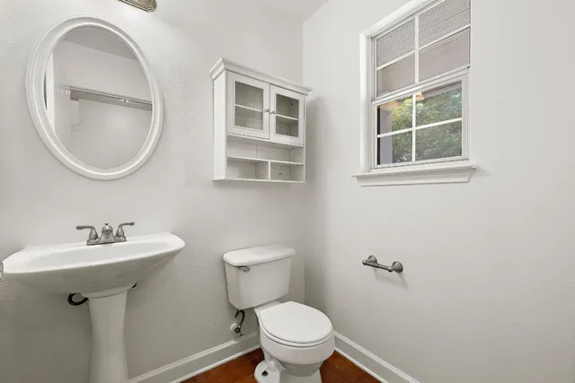 a bathroom with a toilet sink and mirror