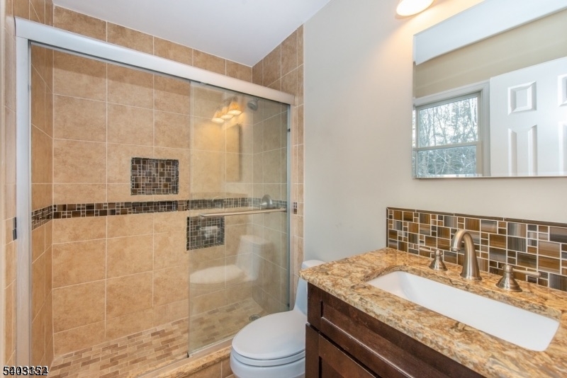 2 Robert Street Flanders, NJ 07836 - Photo 18 of 38 a bathroom with a granite countertop sink toilet a mirror and shower