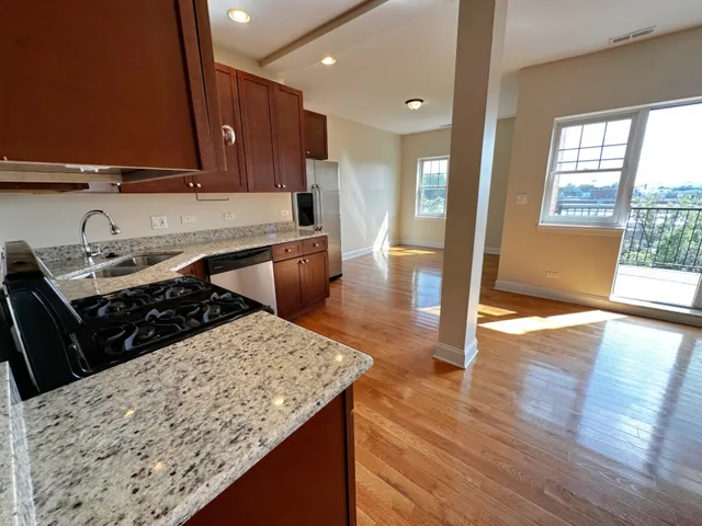 a kitchen with stainless steel appliances granite countertop wooden cabinets a stove top oven a sink and dishwasher