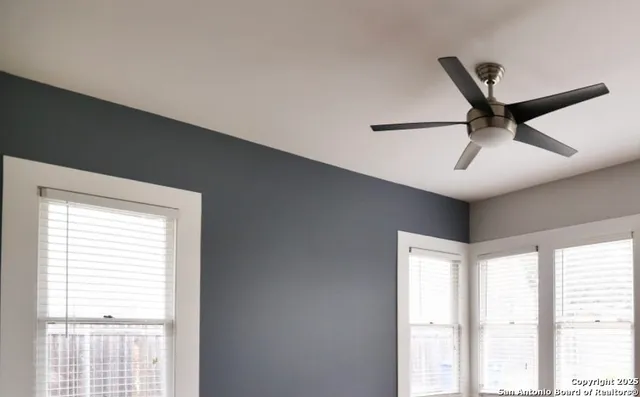 a room with a window and a ceiling fan