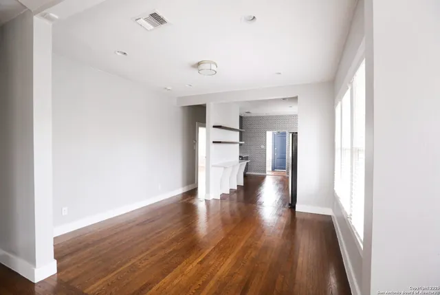 a view of empty room with wooden floor