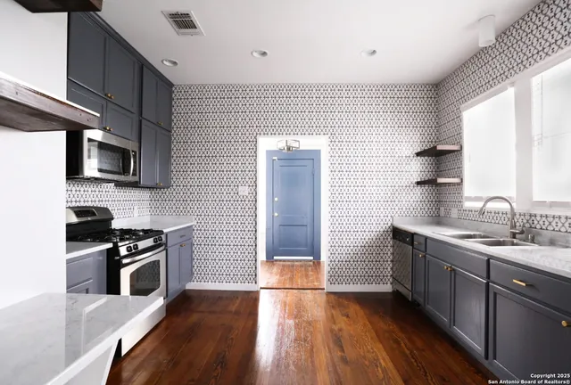 a kitchen with a sink a microwave and cabinets