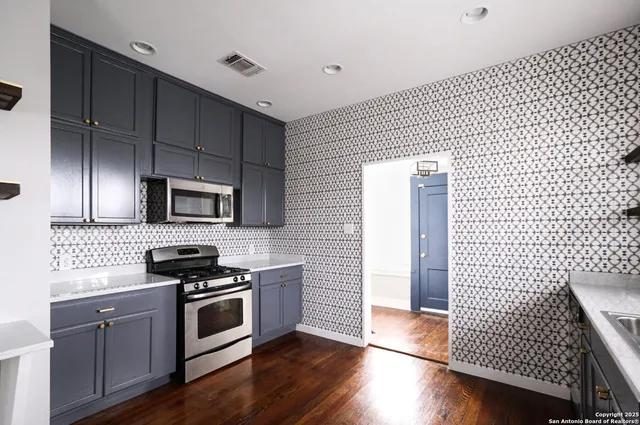 a kitchen with stainless steel appliances kitchen island granite countertop a refrigerator and a stove