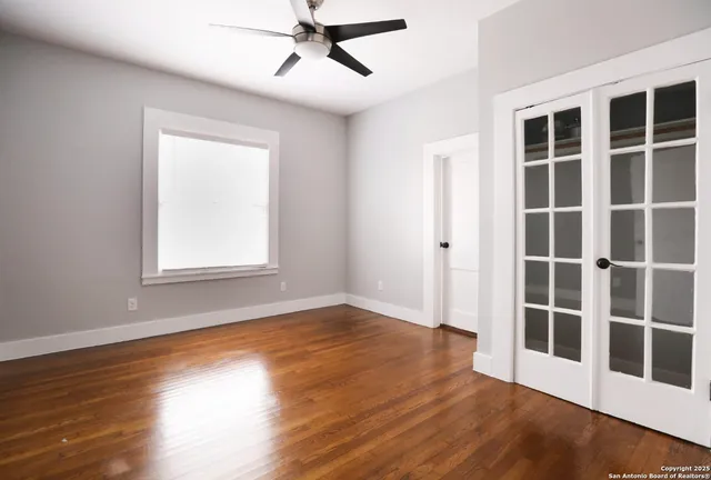 a view of empty room with wooden floor and windows