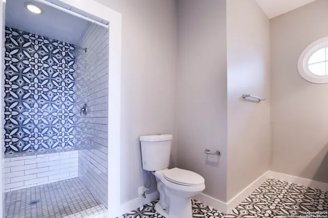 a bathroom with a toilet and a shower