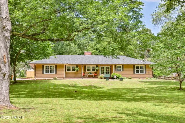 a front view of house with yard and green space