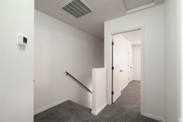 1735 West 540 North, Unit 1805 St. George, UT 84770 - Photo 40 of 64 Upper-level landing featuring textured gray carpet, white baseboards, and a white wall-mounted thermostat