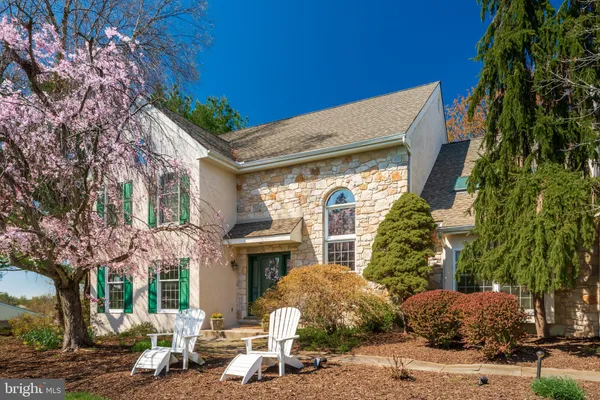 a kitchen with stainless steel appliances granite countertop wooden cabinets a refrigerator a stove a sink and dishwasher with wooden floor