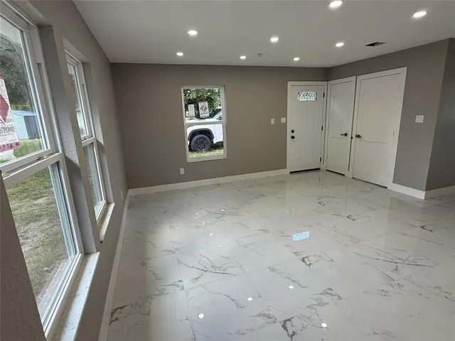 a view of a hallway with stainless steel appliances