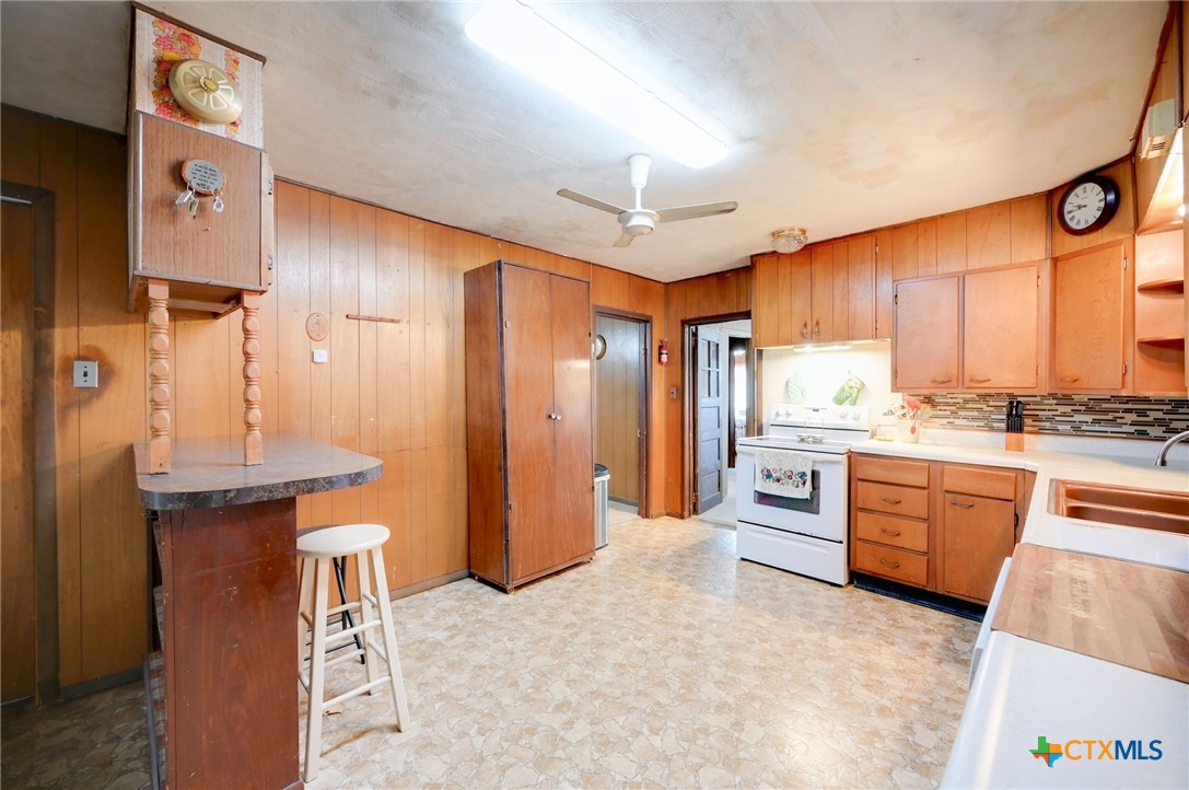 1631 East Fannin Street Luling, TX 78648 - Photo 8 of 27 a large kitchen with stainless steel appliances kitchen island granite countertop a refrigerator and a stove top oven