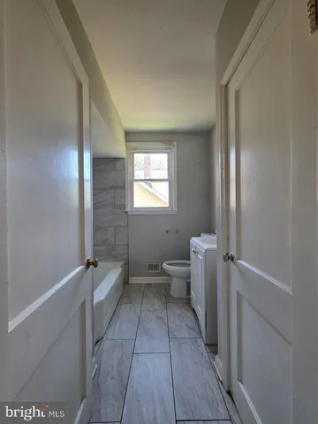 a room with a toilet and a exposed radiator