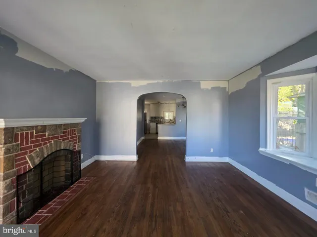 a view of a livingroom with wooden floor and a fireplace