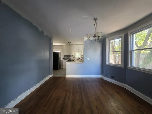 a view of a kitchen with wooden floor electronic appliances and windows