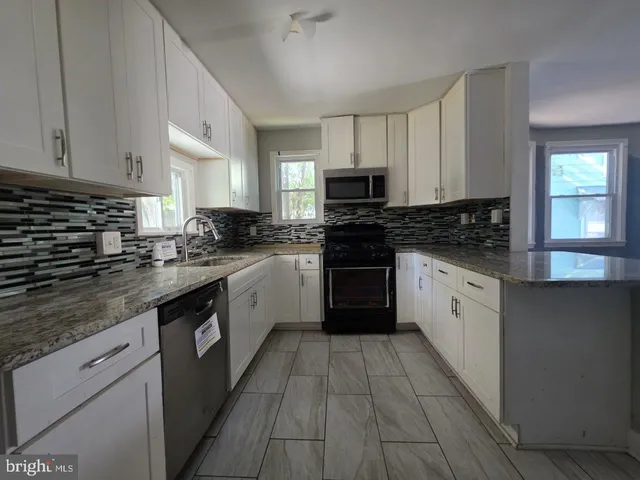 a kitchen with stainless steel appliances granite countertop a stove a sink dishwasher and a refrigerator