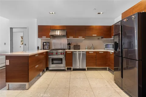 a kitchen with stainless steel appliances a stove a sink and a refrigerator