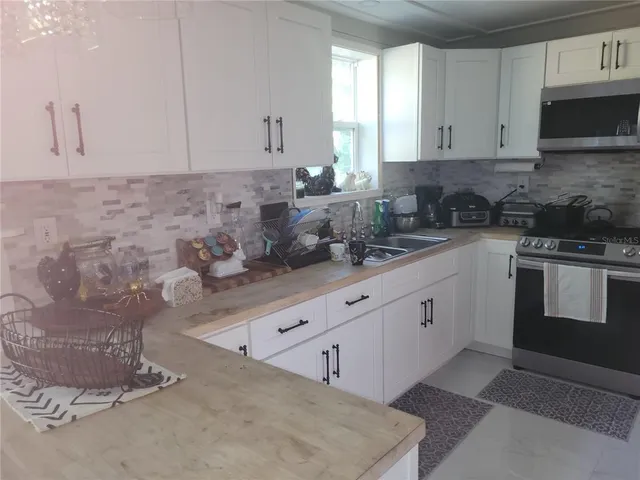 a kitchen with stainless steel appliances granite countertop a refrigerator sink and cabinets