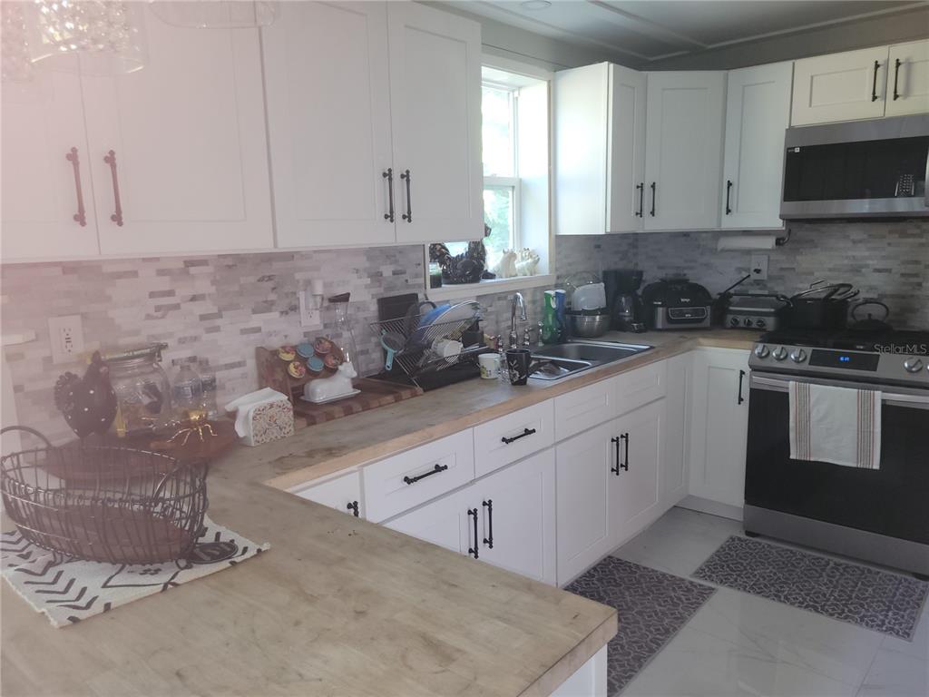821 South Honey Way Inverness, FL 34450 - Photo 14 of 38 a kitchen with stainless steel appliances granite countertop a stove a sink and white cabinets