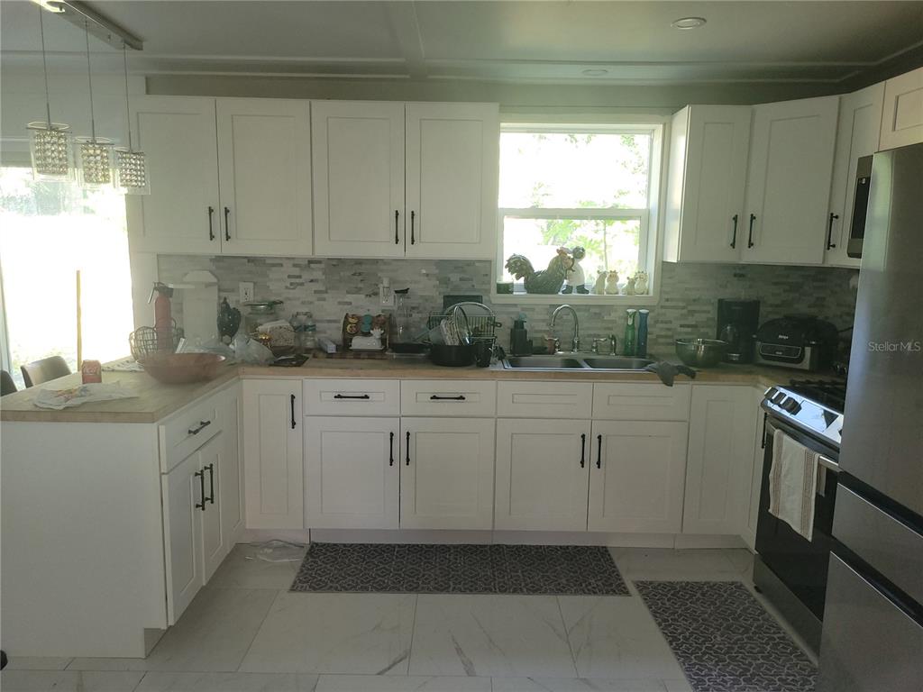 821 South Honey Way Inverness, FL 34450 - Photo 16 of 38 a kitchen with white cabinets and window