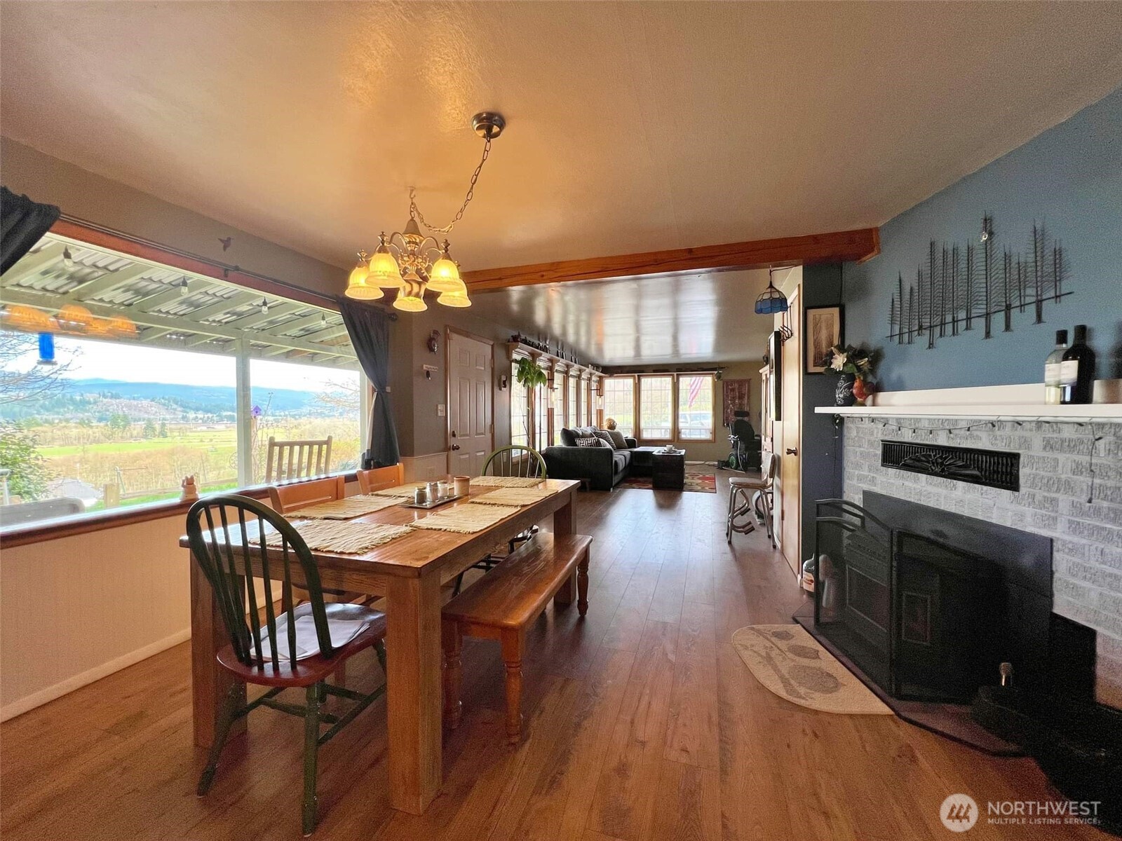 278 Wilson Road Mossyrock, WA 98564 - Photo 19 of 33 a dining room with wooden floor a chandelier a wooden table and chairs