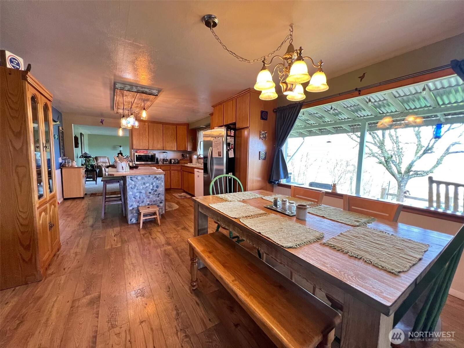 278 Wilson Road Mossyrock, WA 98564 - Photo 28 of 33 a dining room with wooden floor a chandelier a wooden table and chairs