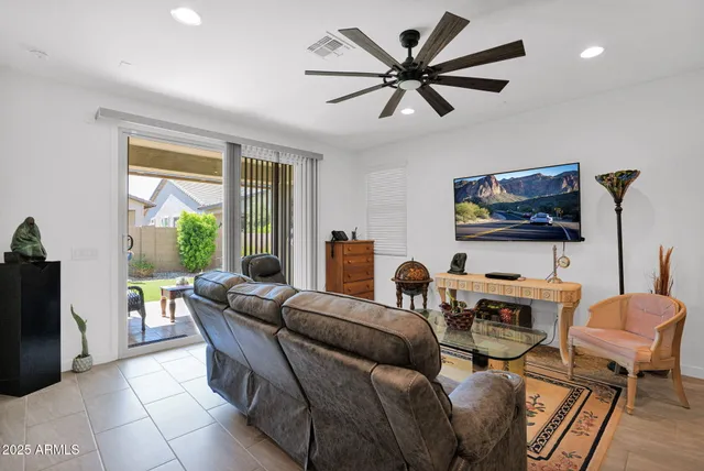 a living room with furniture a flat screen tv and a large window