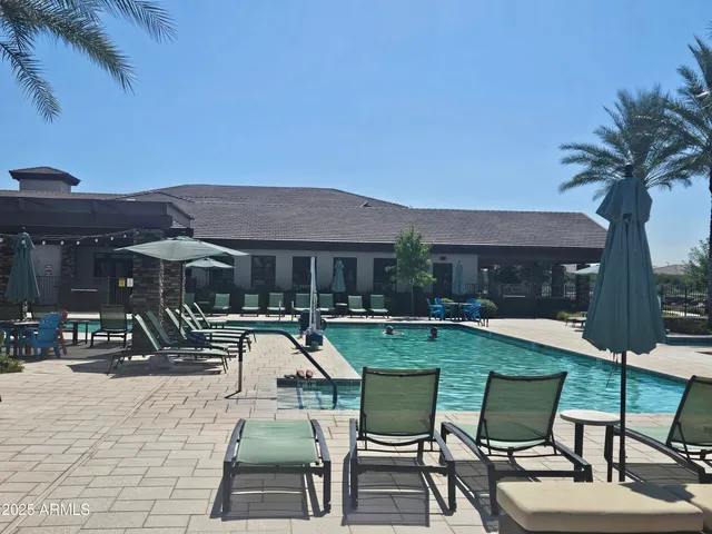 a view of a patio with table and chairs under an umbrella with a fire pit