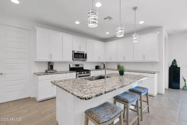 a kitchen with granite countertop kitchen island cabinets and wooden floor