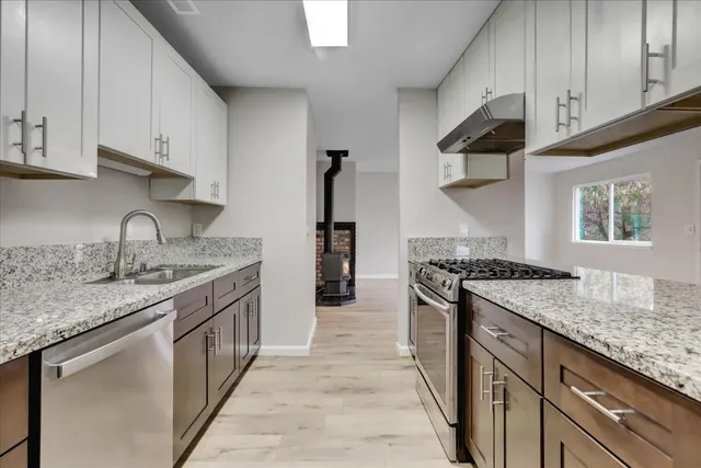 a kitchen with granite countertop a sink and cabinets