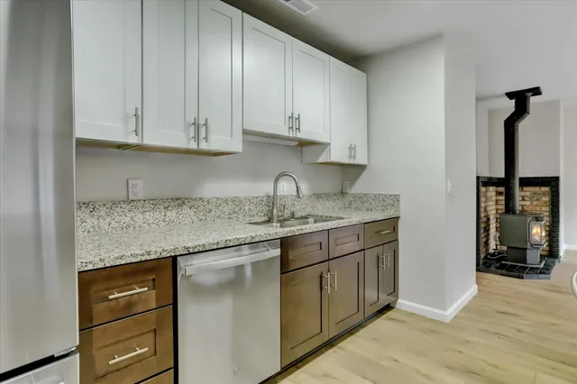 an empty room with wooden floor ceiling fan and windows