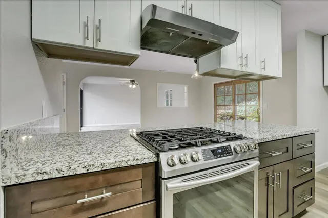 an empty room with a window and ceiling fan