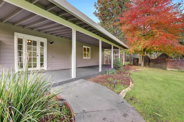 an empty room with wooden floor a ceiling fan and windows
