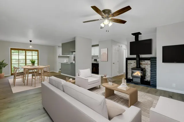 a view of an empty room with window and wooden floor